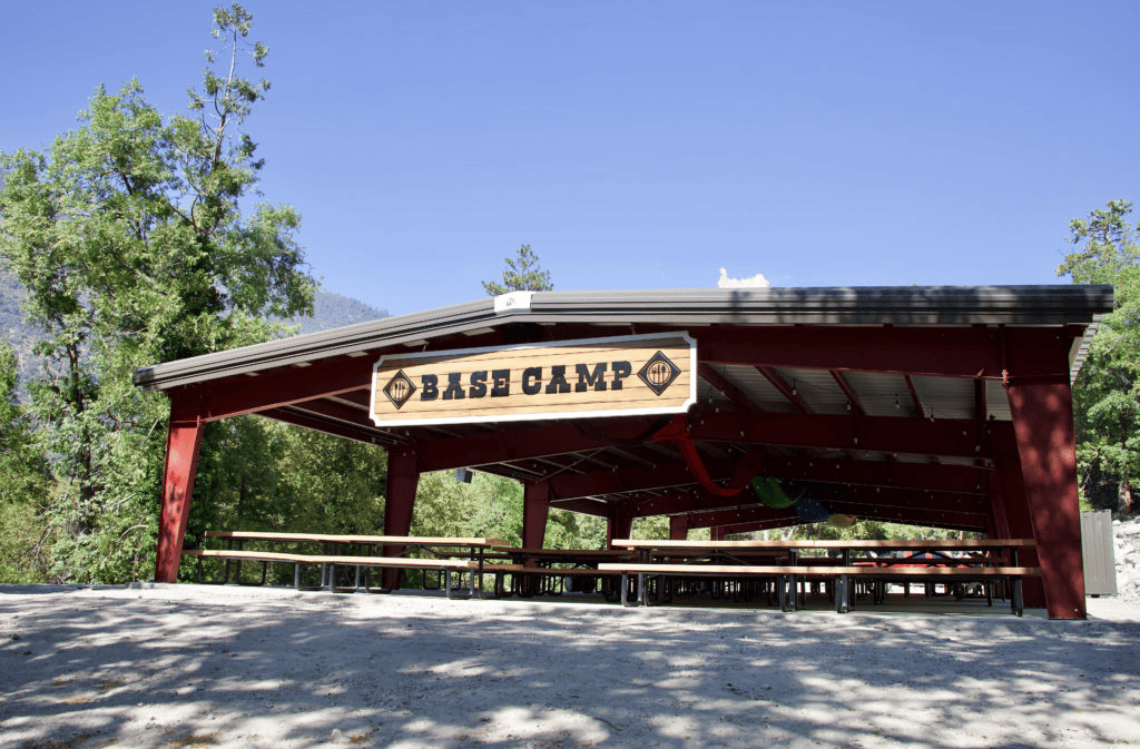 Outdoor covered meeting space with seeting under it and a sign that read "base camp"