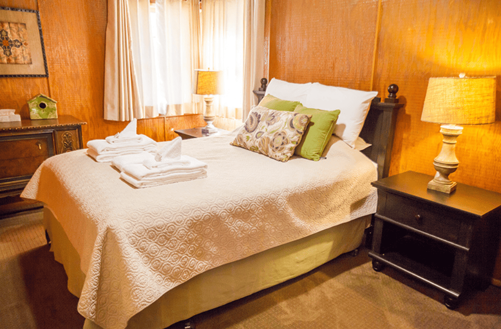 Room with a double bed in it with two night stands with lamps on them